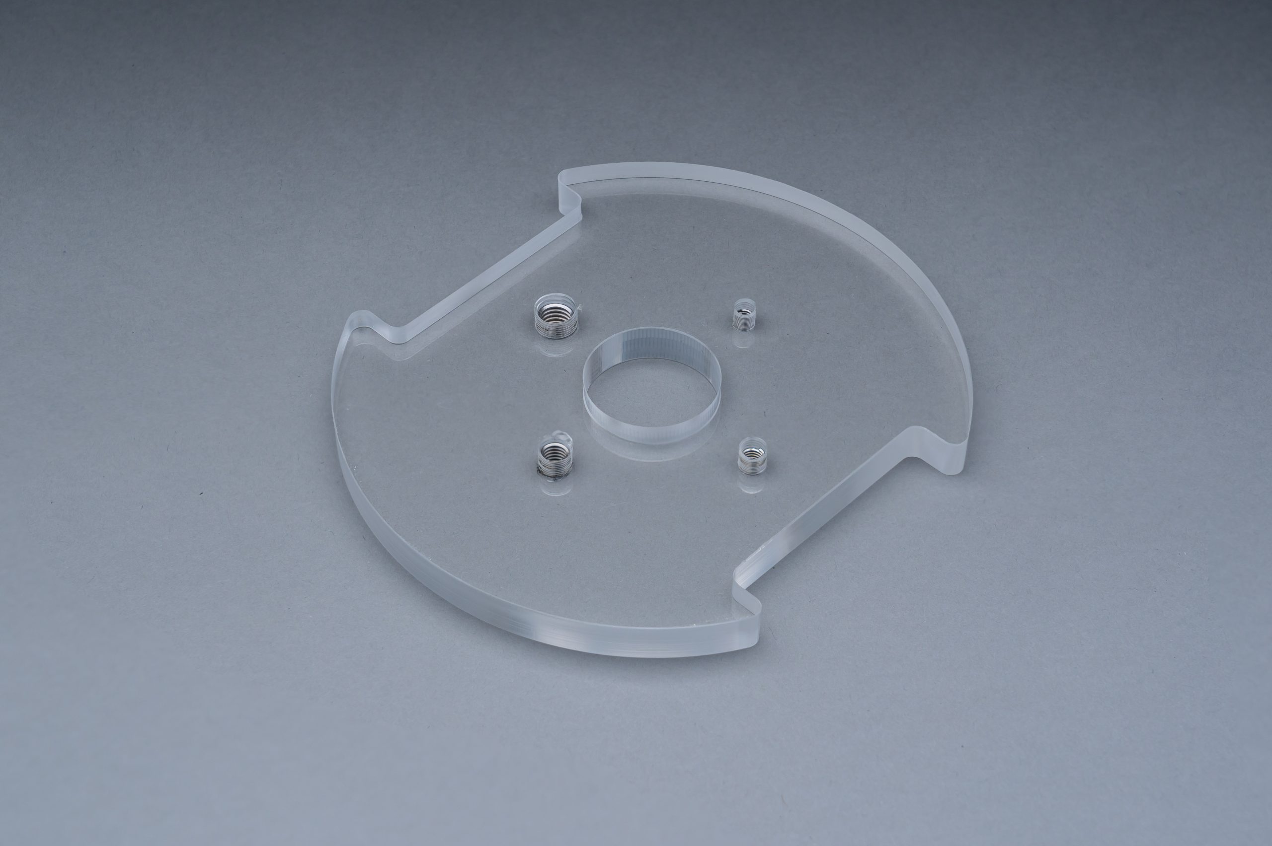 A clear resin sample part with threaded inserts