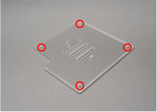 A cover part for a machine made of transpiration resin (Acrylic) with tapped holes.