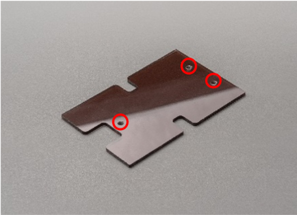 A brown cover part for a machine made of transpiration resin (PVC) with tapped holes.